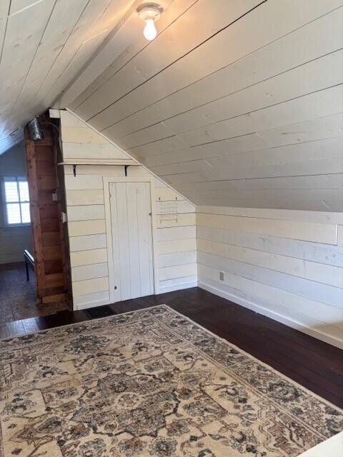 bonus room featuring dark wood-type flooring, wood walls, lofted ceiling, and wooden ceiling