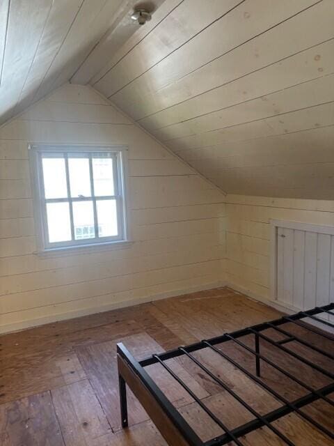 bonus room with wood-type flooring and vaulted ceiling