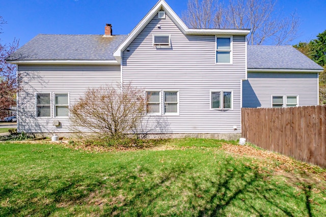 view of side of home featuring a chimney and a shingled roof