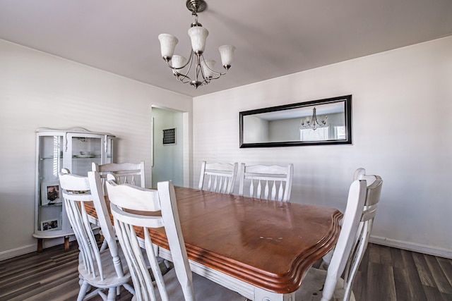 dining space featuring a chandelier, wood finished floors, and baseboards