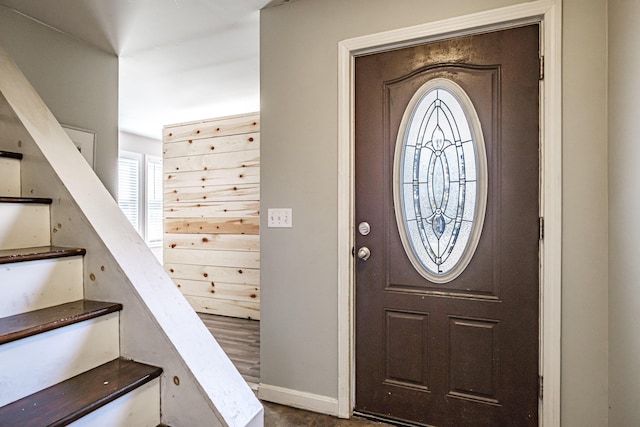 foyer entrance featuring stairs and baseboards