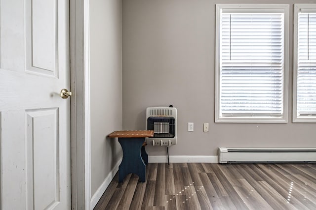 miscellaneous room featuring heating unit, baseboards, dark wood finished floors, and baseboard heating
