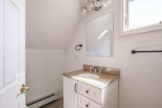 bathroom featuring a baseboard heating unit, vanity, and vaulted ceiling
