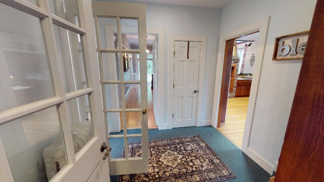 hallway with carpet floors and baseboards