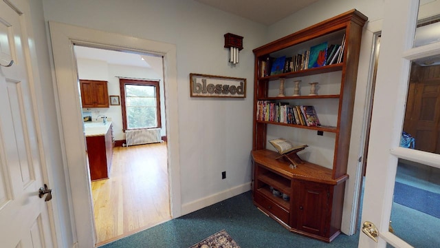 corridor featuring baseboards, dark wood finished floors, and radiator