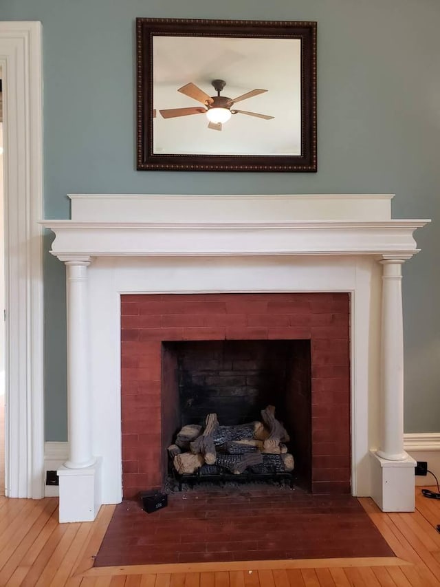 details with a ceiling fan, a fireplace with flush hearth, and wood finished floors