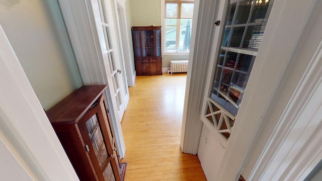 corridor with radiator and light wood-style flooring
