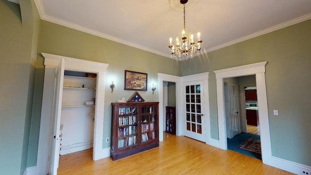 dining area featuring crown molding, a notable chandelier, baseboards, and light wood-style floors
