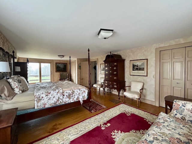 bedroom featuring access to exterior, wood finished floors, and baseboards