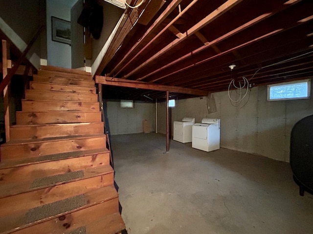 below grade area featuring stairs, washing machine and clothes dryer, and heating fuel