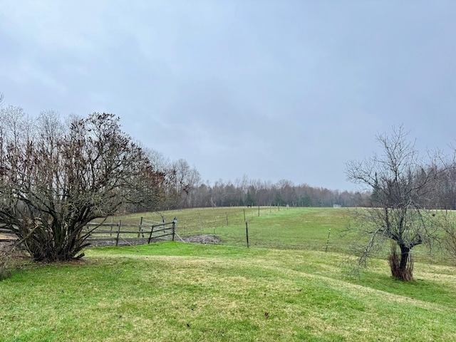 view of yard featuring fence and a rural view