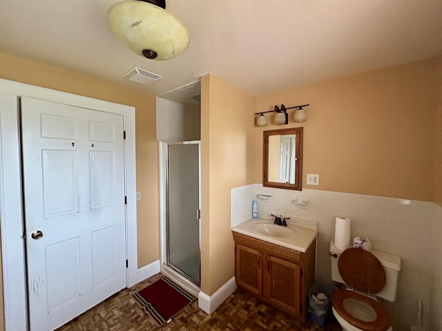 bathroom with visible vents, a stall shower, toilet, tile walls, and vanity