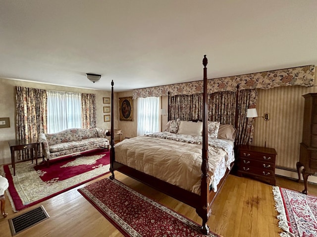 bedroom featuring wood finished floors and visible vents