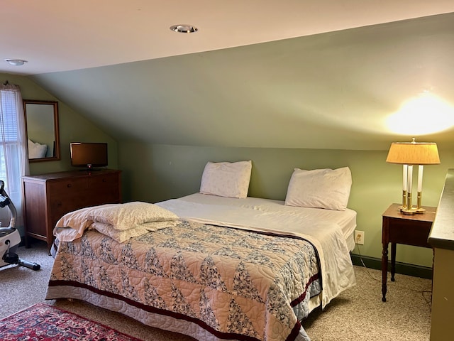 bedroom with lofted ceiling, baseboards, and carpet floors