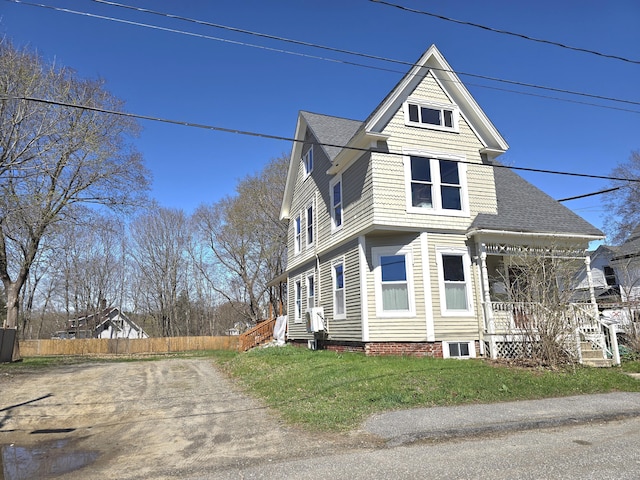 10 Middle St, Lisbon, ME 04252 - view of front of home with covered porch, a front yard, fence, and roof with shingles