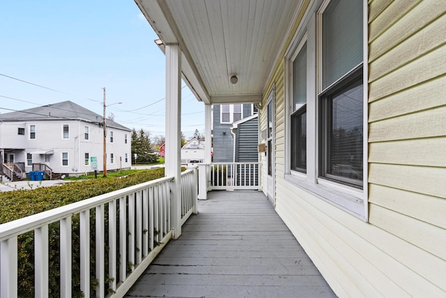 wooden terrace featuring a residential view and covered porch