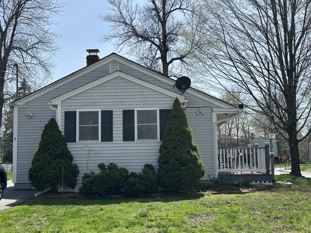 view of property exterior with a chimney and a yard