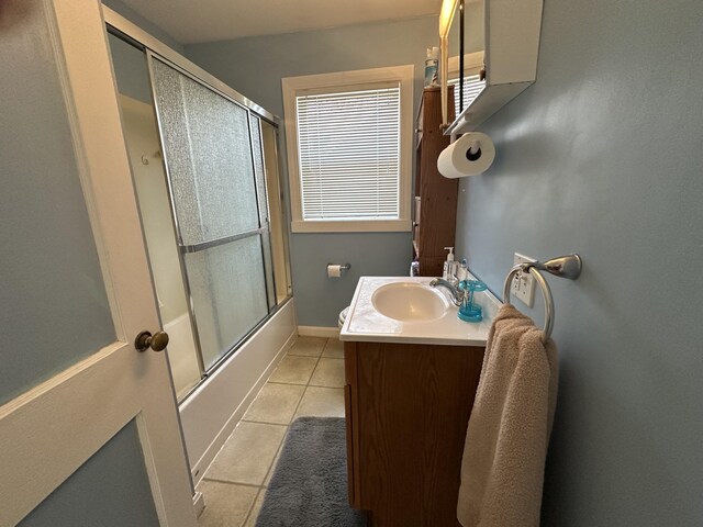 bathroom with tile patterned floors, bath / shower combo with glass door, and vanity