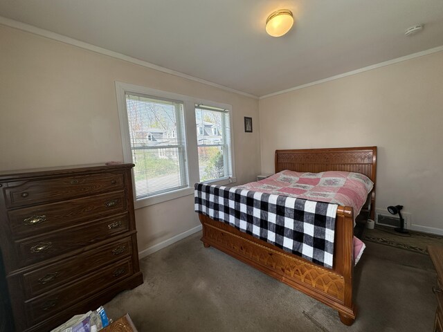 bedroom with baseboards, ornamental molding, and dark carpet