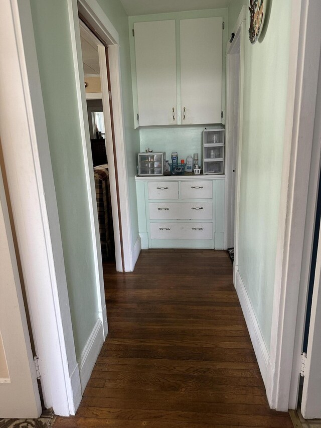 hall with baseboards and dark wood finished floors