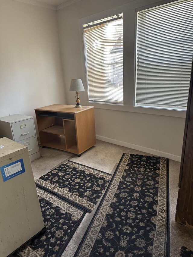 office space with crown molding, baseboards, and light colored carpet