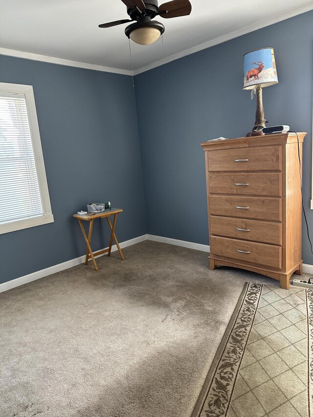 carpeted empty room with baseboards, ceiling fan, and ornamental molding