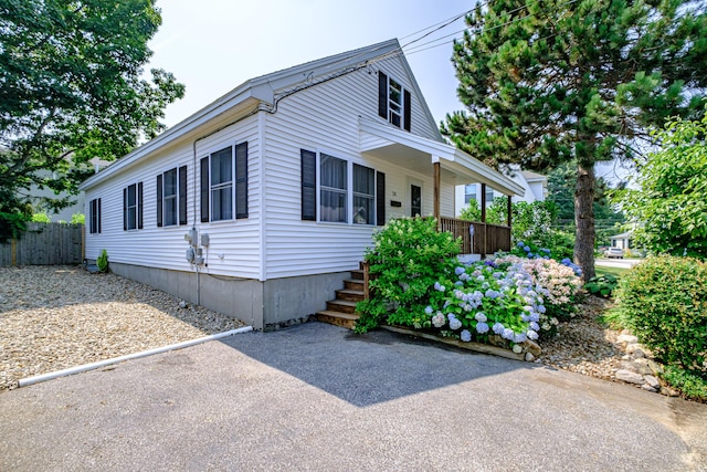 view of home's exterior with fence and covered porch