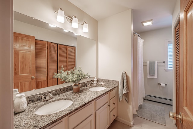 full bath featuring a sink, tile patterned floors, baseboard heating, and double vanity