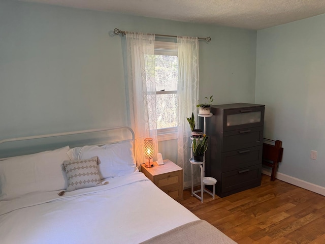 bedroom with wood finished floors and baseboards
