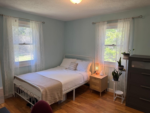 bedroom featuring wood finished floors and a textured ceiling