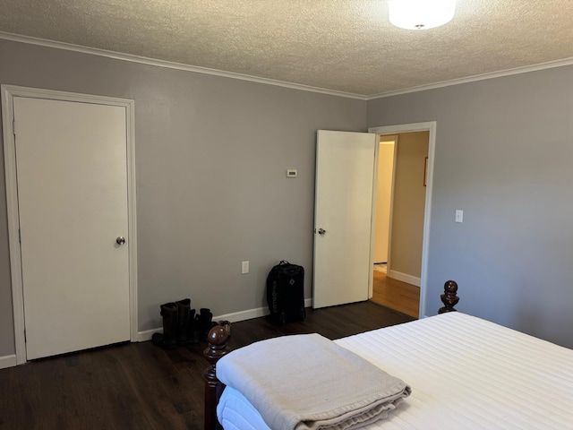 bedroom with crown molding, a textured ceiling, wood finished floors, and baseboards