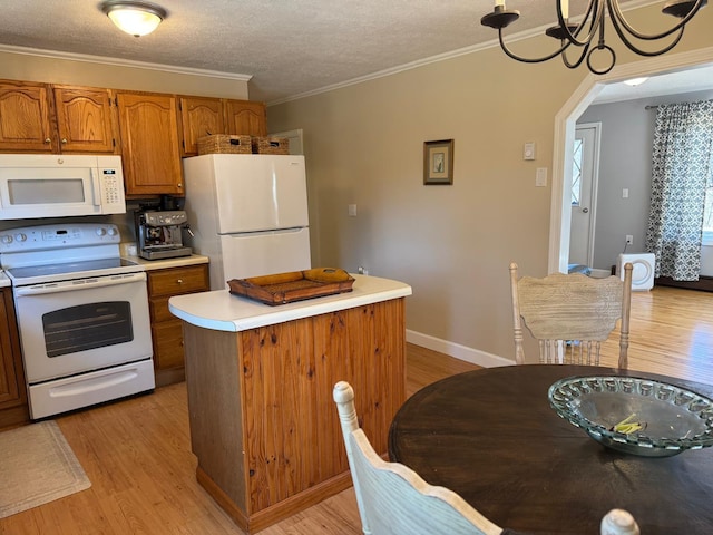 kitchen featuring brown cabinets, light wood-style floors, light countertops, a kitchen island, and white appliances