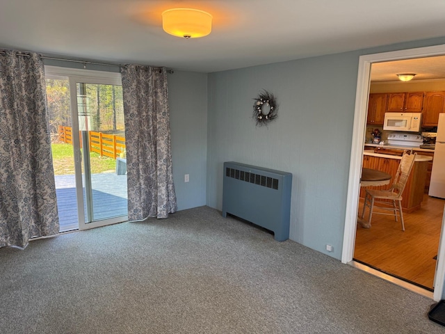 living area featuring radiator heating unit and light carpet