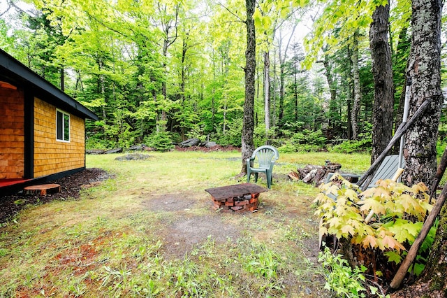 view of yard with a fire pit and a forest view