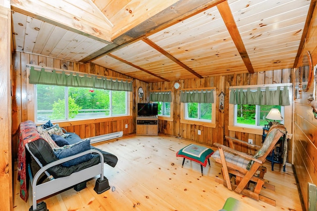 living area with plenty of natural light, a baseboard radiator, lofted ceiling, and wood walls