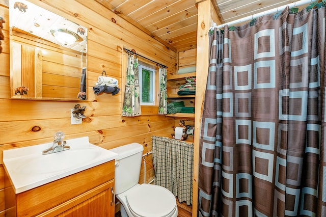 full bath featuring vanity, wood walls, and toilet