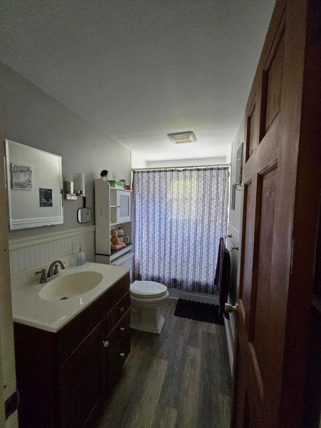 9 Allen Avenue Ext, Falmouth, ME 04105 - full bath featuring vanity, toilet, shower / bathtub combination with curtain, and wood finished floors
