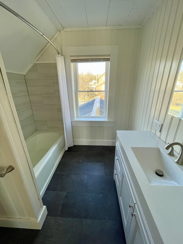 bathroom with tile patterned flooring, lofted ceiling, shower / bathtub combination with curtain, and vanity