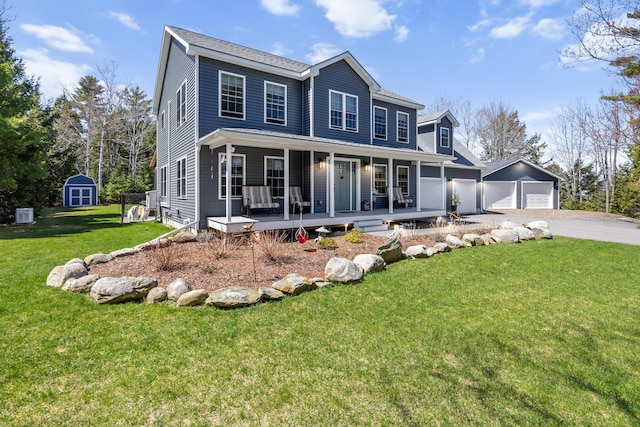 35 Graystone Dr, Hampden, ME 04444 - colonial home featuring a front lawn, driveway, a shed, a porch, and an outbuilding