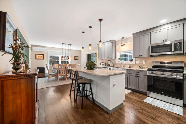 35 Graystone Dr, Hampden, ME 04444 - kitchen with appliances with stainless steel finishes, light stone counters, a center island, tasteful backsplash, and gray cabinetry