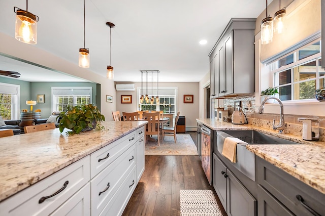 35 Graystone Dr, Hampden, ME 04444 - kitchen with light stone countertops, dark wood-style floors, a wall mounted AC, a sink, and decorative light fixtures