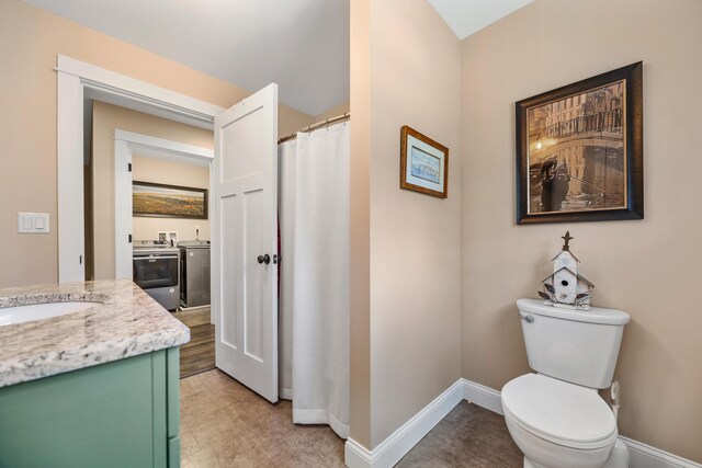 35 Graystone Dr, Hampden, ME 04444 - full bathroom featuring vanity, curtained shower, toilet, baseboards, and washing machine and clothes dryer