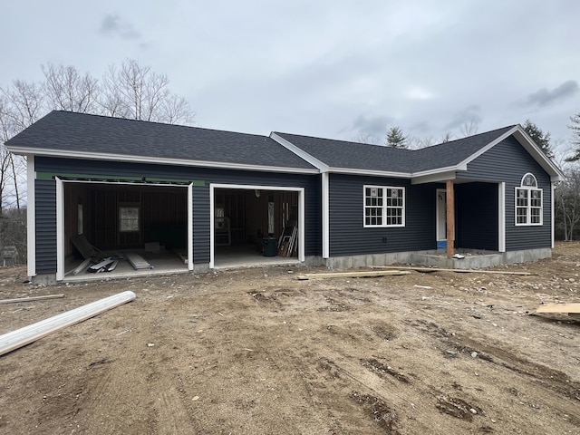 view of front facade with an attached garage and a shingled roof