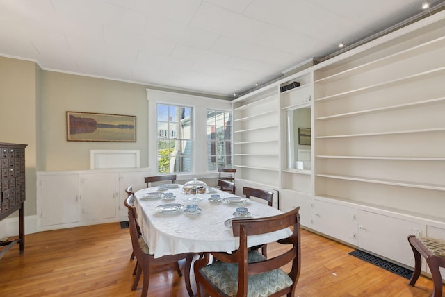11 Linden St, Bath, ME 04530 - dining area with visible vents, light wood-style flooring, crown molding, and built in shelves