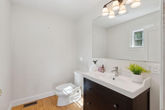 11 Linden St, Bath, ME 04530 - bathroom featuring toilet, baseboards, visible vents, vanity, and wood finished floors