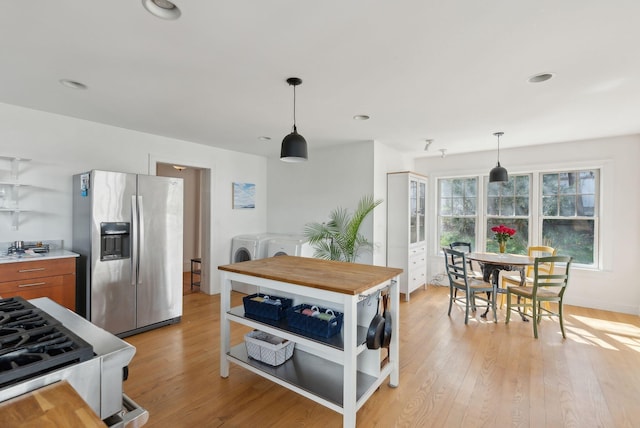 11 Linden St, Bath, ME 04530 - kitchen featuring stainless steel fridge with ice dispenser, washing machine and dryer, light wood-type flooring, and pendant lighting