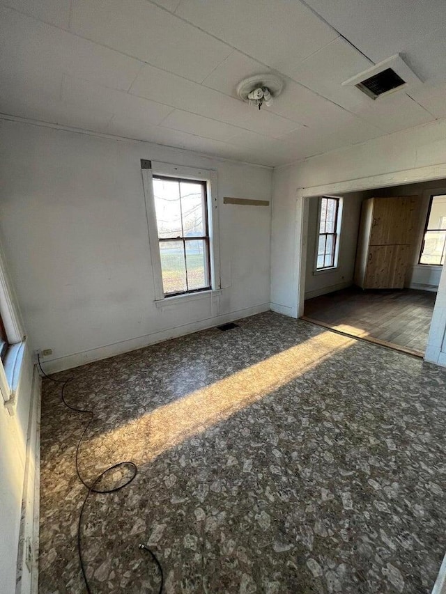 spare room with baseboards and visible vents