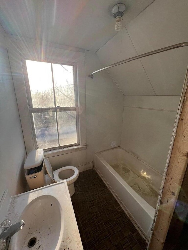 bathroom featuring toilet, tub / shower combination, and a sink