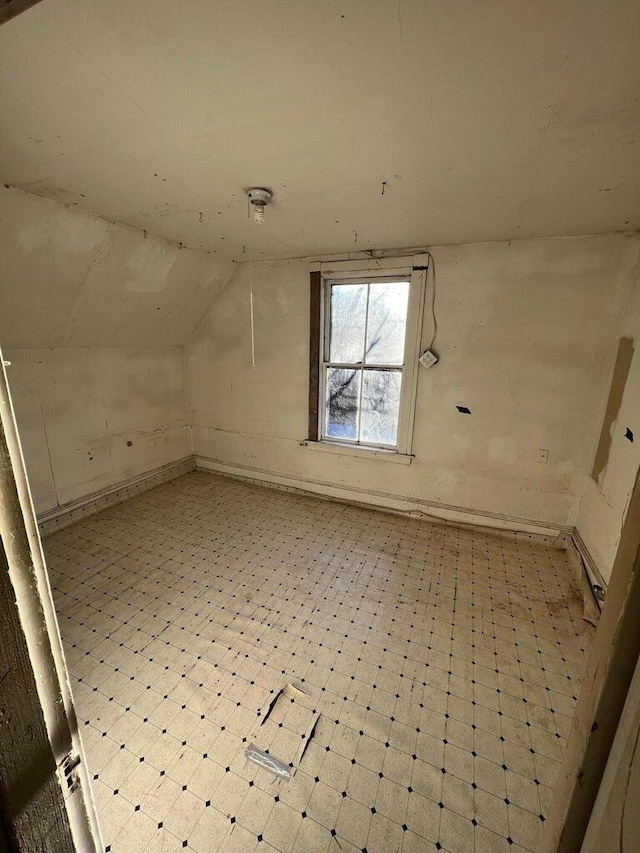 additional living space with tile patterned floors and vaulted ceiling