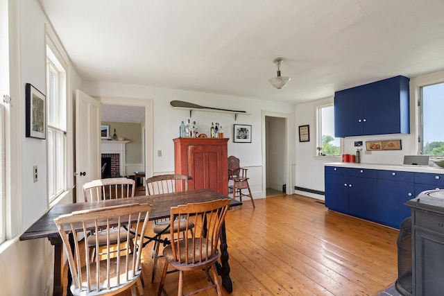 651 N Shore Rd, North Haven, ME 04853 - dining area featuring plenty of natural light, light wood-style flooring, baseboard heating, and a fireplace
